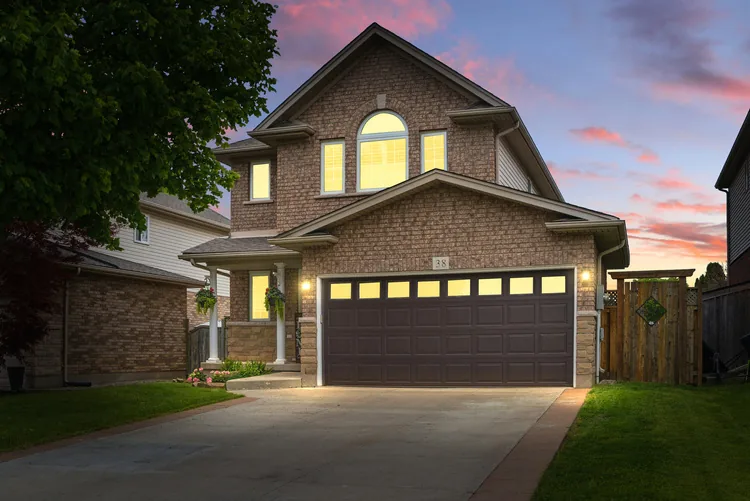 Home with lit garage at twilight